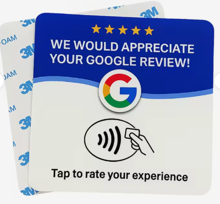 Placa NFC de Reseñia: tarjeta azul con cinco estrellas doradas, el texto «We would appreciate your Google review», el logo de Google y el icono de acercar el móvil. Detrás se ve el adhesivo 3M de la parte trasera.